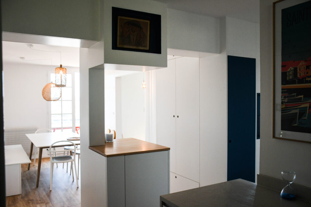 Cuisine blanche avec plan de travail bois et rangements optimisés, appartement Ciboure